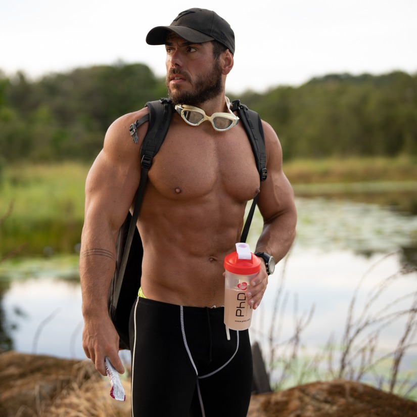 Ross Edgley with goggles around his neck and holding PhD shaker